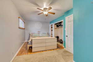 Bedroom with a closet, ceiling fan, and light wood-type flooring