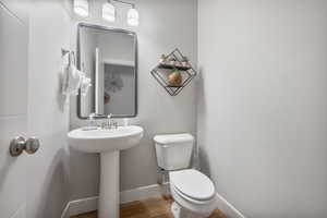 Bathroom with hardwood / wood-style flooring, sink, and toilet