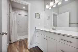 Bathroom featuring wood-type flooring, curtained shower, and vanity