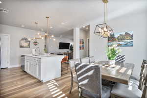 Dining room with sink and light wood-type flooring