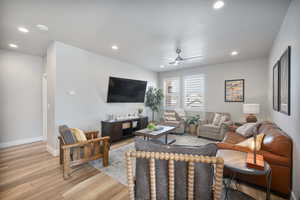 Living room with ceiling fan and light wood-type flooring