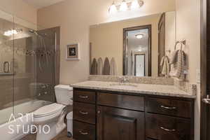 Full bathroom for bedroom 3,  featuring shower / bath combination with glass door, vanity, and toilet