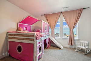 Carpeted bedroom with a water view