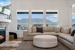 Living room featuring a water and mountain view, a stone fireplace, and a wealth of natural light