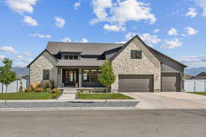 View of front of house featuring a mountain view, a garage, a front yard, and covered porch