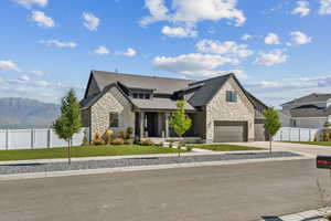 View of front facade featuring a mountain view, a garage, and a front lawn