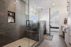 Bathroom with vanity, tile patterned floors, and a shower with shower door