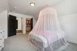 Carpeted bedroom with a closet, lofted ceiling, a spacious closet, and a textured ceiling