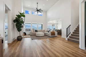 Living room with light hardwood / wood-style flooring, a chandelier, and a high ceiling