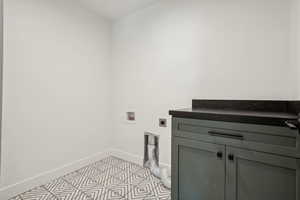 Clothes washing area featuring cabinets, washer hookup, and electric dryer hookup