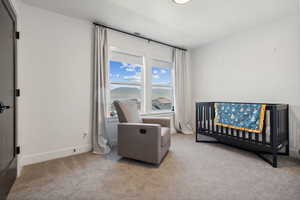 Carpeted bedroom featuring a crib