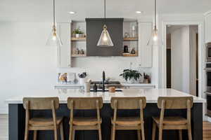 Kitchen with white cabinetry, pendant lighting, and a spacious island