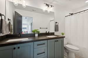 Bathroom with vanity, toilet, and a shower with shower curtain