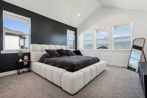 Bedroom featuring vaulted ceiling and light carpet