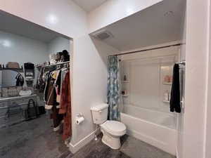 Bathroom featuring shower / bath combination with curtain and toilet