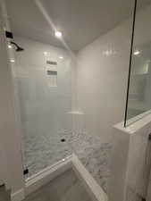 Bathroom featuring tiled shower and tile patterned flooring