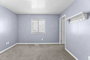 Carpeted empty room with a textured ceiling