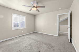 Spare room with ceiling fan, light colored carpet, and a textured ceiling