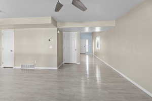 Empty room featuring light wood-type flooring and ceiling fan