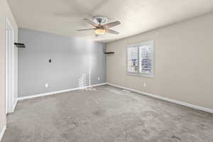 Carpeted spare room with a textured ceiling and ceiling fan