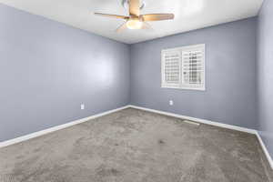 Carpeted spare room with a textured ceiling and ceiling fan