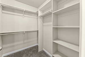 Walk in closet featuring dark colored carpet