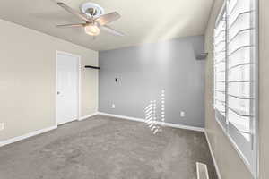 Carpeted spare room with ceiling fan and plenty of natural light