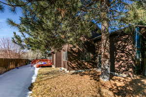 View of side of home with a wooden deck and a yard