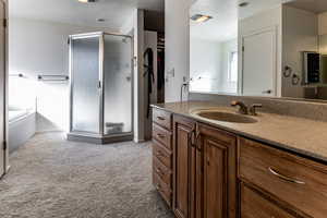 Bathroom with vanity, shower with separate bathtub, and a textured ceiling