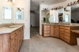 Bathroom with vanity, ceiling fan, and a textured ceiling