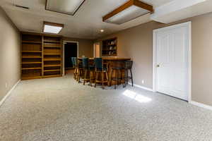 Bar with carpet floors and a textured ceiling