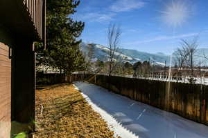 Yard layered in snow featuring a mountain view