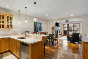 Kitchen featuring sink, a kitchen breakfast bar, dishwashing machine, kitchen peninsula, and pendant lighting
