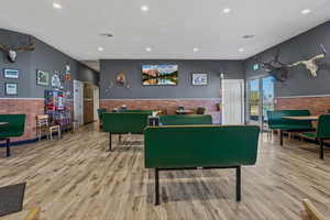 Rec room featuring light hardwood / wood-style flooring and brick wall