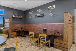 Dining room featuring brick wall and light wood-type flooring