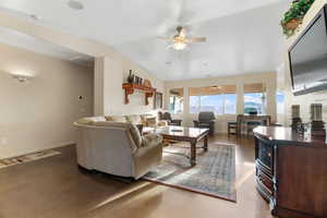 Living room featuring vaulted ceiling and ceiling fan