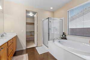 Ensuite bathroom with vanity, shower with separate bathtub, and concrete flooring