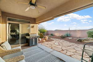 View of patio featuring a grill and ceiling fan and fenced yard with views