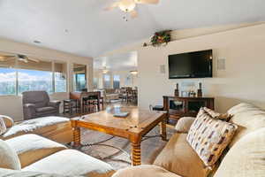 Living room featuring lofted ceiling, and ceiling fan