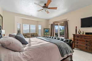 Owners suite with carpet, a ceiling fan, and a sliding glass door to access the exterior