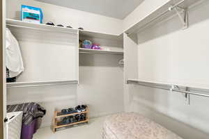 Spacious walk-in closet featuring carpet flooring for the primary owners suite