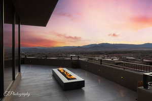 Patio terrace at dusk featuring a mountain view and an outdoor fire pit