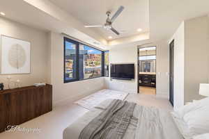 Ensuite Bedroom with a raised ceiling and ceiling fan