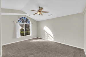 Empty room with lofted ceiling, ceiling fan, and carpet