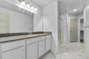 Bathroom with vanity and a shower with shower door