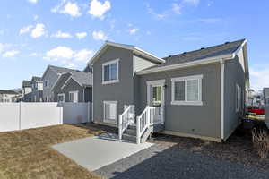 Rear view of property featuring a yard and a patio