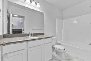 Full bathroom with vanity, bathtub / shower combination, and toilet