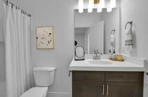 Bathroom featuring vanity, toilet, and a shower with shower curtain