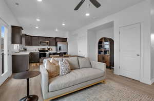 Living room featuring ceiling fan, sink, and light wood-type flooring