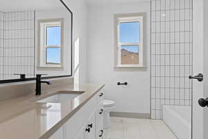 Bathroom featuring vanity, toilet, and a healthy amount of sunlight